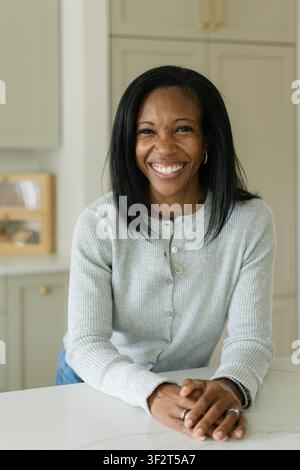 Glückliche schwarze Frau lächelt in einer modernen Küche Stockfoto