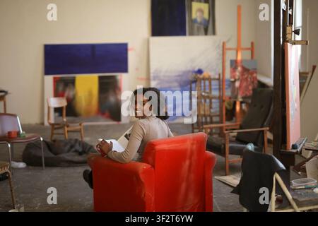 Glückliche junge Frau entspannt in einem kreativen Kunststudio Stockfoto