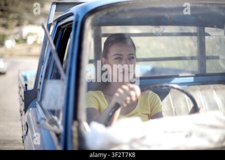 Junge Frau fährt einen alten blauen Pickup-Truck Stockfoto