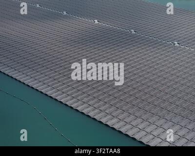 Luftaufnahme einer großen schwimmenden Solarfarm mit Reihen von Photovoltaikpanelen, die auf der Wasseroberfläche in den Niederlanden installiert sind. Stockfoto