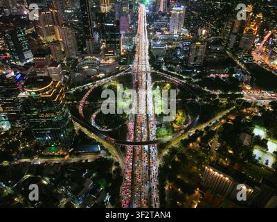 Luftbild des Semanggi-Kreuzungsbereichs bei Nacht mit starkem Verkehr, der durch die beleuchtete urbane Landschaft von Wolkenkratzern und Stadtlichtern in Seti fließt Stockfoto