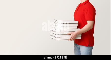 Pizza-Lieferung jederzeit möglich. Courier hält viele Kisten Pizza Stockfoto