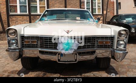 Berlin, Deutschland – 3. Mai 2026. Frontansicht eines weißen klassischen Cadillac Calais mit türkisfarbenen Hochzeitsdekorationen, ausgestellt auf dem Oldtimer Open Air in Zita Stockfoto
