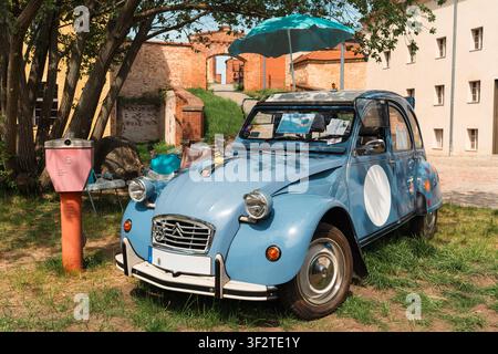 Berlin, Deutschland – 3. Mai 2026. Blauer Citroen 2CV, mit Blumen geschmückt und unter einem türkisfarbenen Schirm ausgestellt auf dem Oldtimer-Freiluftfest an der Zitadelle Sp Stockfoto