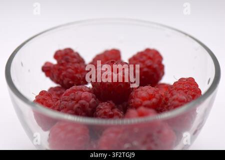 Frische reife Himbeeren in einer Glasschale auf weißem Hintergrund, Nahaufnahme Stockfoto