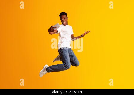 Gutaussehender afrikanischer Kerl macht selfie beim Springen Stockfoto