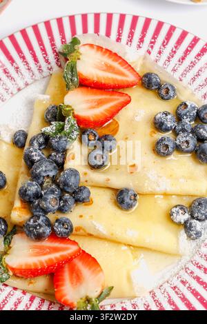 Nahaufnahme-Makroaufnahme von Pfannkuchen mit Blaubeeren, Erdbeeren und Puderzucker, isoliert. Stockfoto