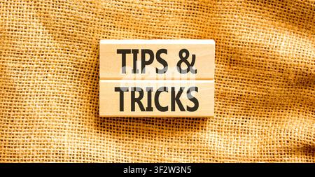 Symbol für Tipps und Tricks. Konzeptwörter Tipps und Tricks auf schönen Holzblöcken. Schöner Leinwandhintergrund. Geschäftliche Tipps und Tricks motivieren Stockfoto