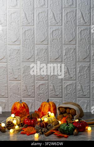 Kürbisse, Walnüsse und Herbstelemente erhellen einen rustikalen Hintergrund und feiern den Herbst und Thanksgiving Stockfoto