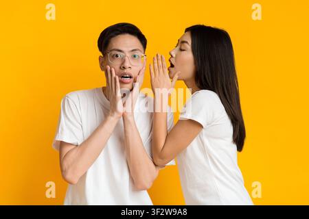 Asiatische junge Frau, die mit ihrem Freund schockierende Nachrichten teilt Stockfoto