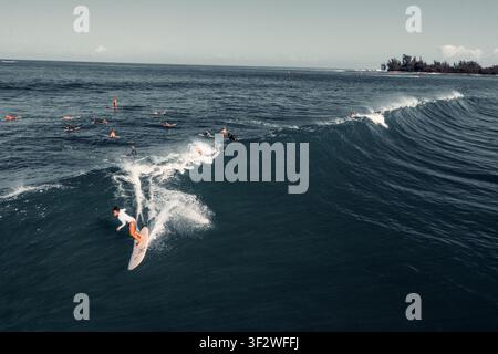 HALEIWA, NORTH SHORE, HAWAII - 19. JANUAR 2022: Eine Luftaufnahme eines Surfers, der in eine sich auflösende Welle an der North Shore abtaucht, mit der Wellenlinie und dem Punkt Stockfoto