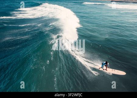 HALEIWA, NORTH SHORE, HAWAII - 19. JANUAR 2022: Eine Luftaufnahme eines Surfers, der unter einer großen brechenden Welle an der North Shore surft. Stockfoto
