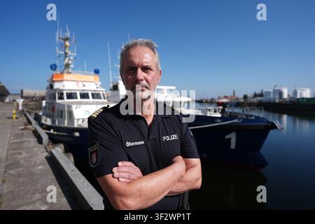 PRODUKTION - 13. Juli 2026, Niedersachsen, Cuxhaven: Toni Öllermann, Chef des Wasserschutzpolizeireviers 4 in Hamburg, steht im Hafen vor dem seetauglichen Küstenpatrouillenboot WS 1 ·Bürgermeister Brauer· (rechts) und seinem Vorgänger, dem Küstenpatrouillenboot ·Bürgermeister Weichmann· (links). Der Zuständigkeitsbereich des Wasserschutzpolizeireviers 4 (WSPK 4) erstreckt sich entlang der Elbe über 77 Seemeilen von Tonne 105/106 vor Stade bis zur Tonne E 3, etwa 15 Seemeilen südlich von Helgoland, sowie das Hamburger Wattenmeer mit seinen Inseln Neuwerk, Scharhörn und Nigehörn. Foto: Marcus Brandt/dpa Stockfoto