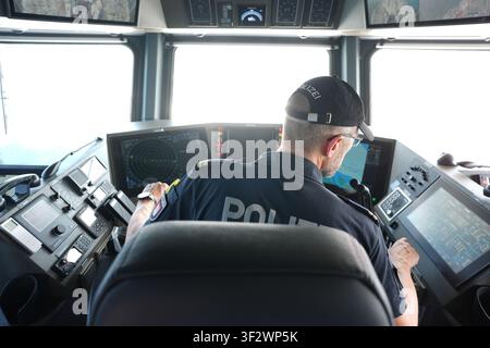 PRODUKTION - 13. Juli 2026, Niedersachsen, Cuxhaven: Alexander Wiegleb, Patrouillenleiter der Hamburger Wasserschutzpolizei, sitzt am Steuer des seetüchtigen Küstenpatrouillenboots WS 1 ·Bürgermeister Brauer· während einer Patrouille auf der Nordsee. Der Zuständigkeitsbereich des Wasserschutzpolizeireviers 4 (WSPK 4) erstreckt sich entlang der Elbe über 77 Seemeilen von Tonne 105/106 nahe Stade bis zur Tonne E 3, etwa 15 Seemeilen südlich von Helgoland, sowie das Hamburger Wattenmeer mit seinen Inseln Neuwerk, Scharhörn und Nigehörn. Foto: Marcus Brandt/dpa Stockfoto