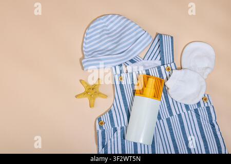 Konzept eines sicheren Strandurlaubs und sorgfältiger Kinderbetreuung während eines Urlaubs. Baby-Sommerutensilien Flat Lay, gestreifter Strampler, Strohhut und Sonnenschutzlos Stockfoto