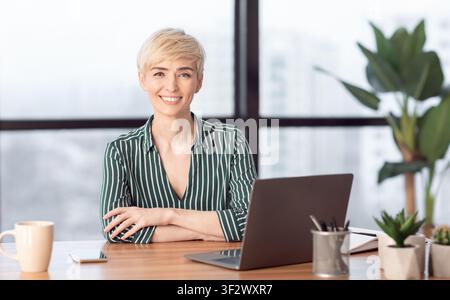Erfolgreiche Geschäftsfrau Bei Laptop Lächelnd Im Modernen Büro Sitzen Stockfoto