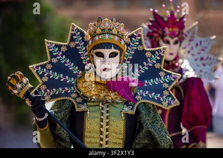 Riquewihr, Frankreich - 04. Juli 2026: Blick auf Teilnehmer in aufwendigen venezianischen Karnevalskostümen und Masken mit kunstvollen Stickereien und goldenem Cr Stockfoto