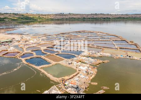 Luftaufnahme der farbenfrohen Salzsiedepfannen am Lake Katwe mit Arbeitern auf Holzstegen in Kasese, Westregion, Uganda. Stockfoto
