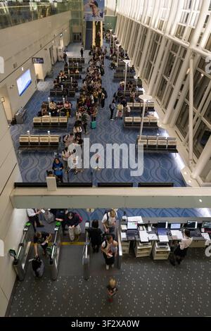 Das Gate 143 am Haneda-Flughafen ist voller Aktivität, während die Passagiere sich für das Boarding anstellen und die effiziente Infrastruktur dieses großen Verkehrsknotenpunkts zeigen Stockfoto
