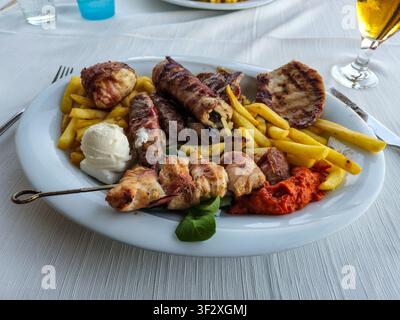 Ein Gericht mit gemischtem Grillgut und Pommes frites oder Chips Stockfoto