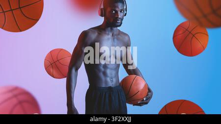 Junger afroamerikanischer Basketballspieler trainiert mit Kopfhörern, Fitnessstudio-Hintergrund Stockfoto