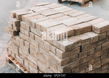 Bauplatten auf einer Holzpalette gestapelt, bereit für den Einsatz in Bau- und Landschaftsgestaltungsprojekten, repräsentierend Baumaterialien Stockfoto