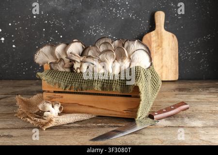 Kiste mit frischen Austernpilzen auf Holztisch Stockfoto