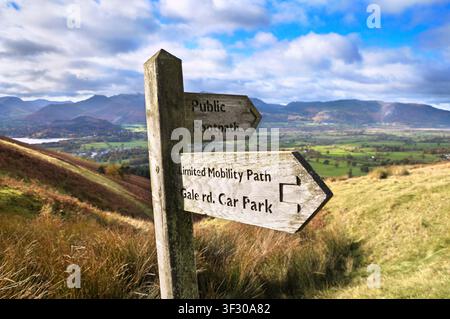 Holzfingerwegweiser / Wegzeichen auf Latrigg Fell mit Hinweisen zu einem Weg für eingeschränkte Mobilität und einem öffentlichen Fußweg, Lake District, Cumbria England UK Herbst Stockfoto