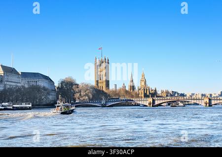 Blick vom Albert Embankment entlang der Themse mit einem Polizeiboot, das in Richtung des Victoria Tower und der Houses of Parliament fährt, London, England, UK Stockfoto