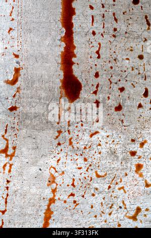 Intensive rote Blutspritzer und eine Pfütze auf einem strukturierten grauen Betonboden, die eine dramatische und spannungsgeladene Atmosphäre für Tatort oder Horror schaffen Stockfoto