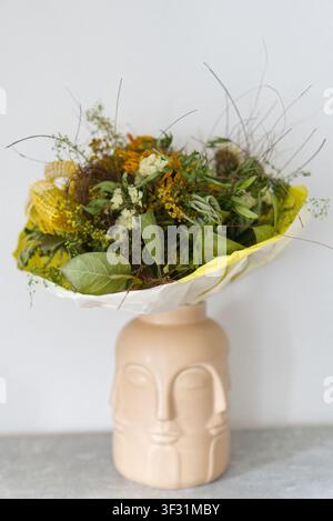 Strauß getrockneter Blumen in einer originellen Keramikgesichtsvase Stockfoto