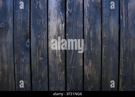 Verwitterte dunkelblaue und graue Holzplatten bilden eine nahtlose vertikale Wandtextur, ideal für rustikale, industrielle und Vintage-Design-Hintergründe. Stockfoto