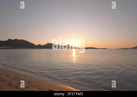 Panoramablick auf den Sonnenaufgang über ruhige Gewässer und den Strand in der Bucht von Pollença, Mallorca Stockfoto