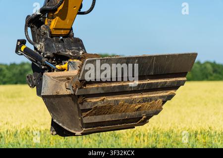 Industrielle Erdbewegungsausrüstung mit Baggerlöffel, hydraulischem Zylinder und Kupplungen auf einer Tiefbau-Baustelle Stockfoto