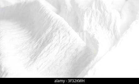 Fließende Falten aus weichem weißem Stoff, die Textur und Tiefe erzeugen Stockfoto