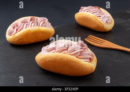 Mini-Schaumkuchen gefüllt mit rosa Erdbeer-Schlagsahne und Trockenfrüchten Stockfoto