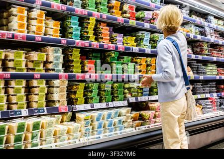 Epsom, London UK, 21. Juli 2026, Seniorin beim Lebensmitteleinkauf und beim Stöbern in vorgepackten Frischen Salaten bei Marks And Spencer Stockfoto