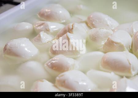 Frische Mozzarellakugeln, die in einer weißen Flüssigkeit schwimmen, eine Nahaufnahme in einem Straßenfood-Markt in Palermo, Sizilien Stockfoto