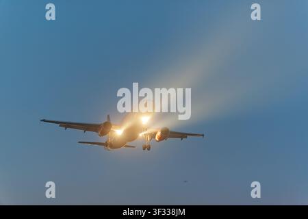 Flugzeug im Flug mit eingeschalteten Lichtern Stockfoto