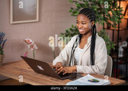 Junge afroamerikanische Frau, die im Home Office am Laptop arbeitet Stockfoto