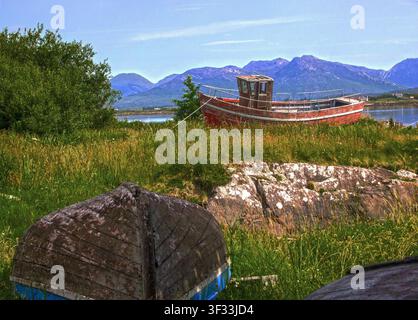 Ein altes Fischerboot, das an Land gezogen, vernachlässigt und zurückgelassen am Ende seines Arbeitslebens liegt. In Roundstone, Connemara, County Galway, Irland Stockfoto