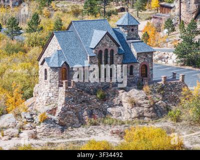 Historische Steinkapelle auf dem Felsen in Allenspark Colorado, umgeben von Herbstlaub Stockfoto