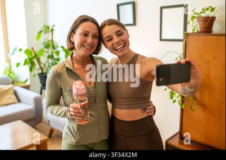 Fröhliche sportliche Frauen, die ein Selfie-Foto auf dem Smartphone machen Stockfoto
