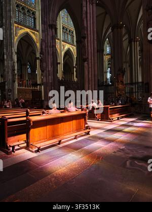 Sonnenlicht, das durch Buntglasfenster in der Kölner Kathedrale in Köln, Nordrhein-Westfalen, Deutschland, strömt. Stockfoto