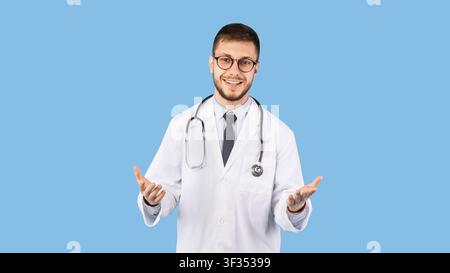 Fröhliche Männliche Arzt In Uniform Im Gespräch Mit Kamera, Blauer Hintergrund Stockfoto