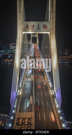 Luftaufnahme der beleuchteten Nanpu-Brücke bei Nacht mit Langzeitbelichtungs-Lichtspuren von fahrenden Fahrzeugen auf der mehrspurigen Autobahn in Shanghai, Shang Stockfoto