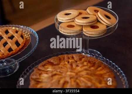 Handgemachte mit Marmelade gefüllte Kekse – occhi di bue, Linzer, brasilianische oder Marmeladen-Shortbread – in einer eleganten Konditorei ausgestellt. Mürbeteig, Fruchtmarmelade, traditionell Stockfoto
