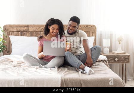 Glücklicher Mann und Frau kaufen Sachen online Stockfoto