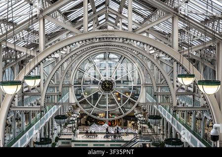 Innenansicht des St. Stephens Green Einkaufszentrums in Dublin, Irland, mit kunstvoller eiserner Uhrkonstruktion und symmetrischer Architektur Stockfoto