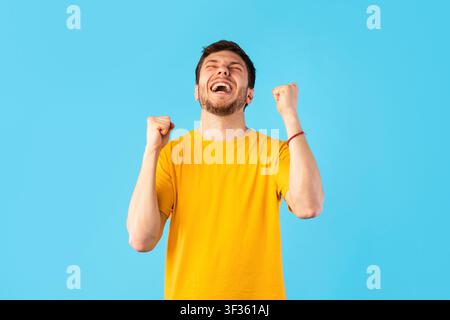 Portrait eines glücklichen Mannes, der mit erhobenen Fäusten schreit Stockfoto